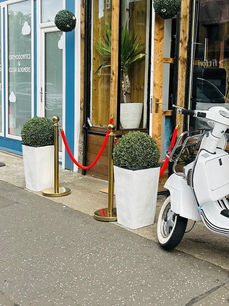 White Vespa parked at the kerb outside Mercia Barbers